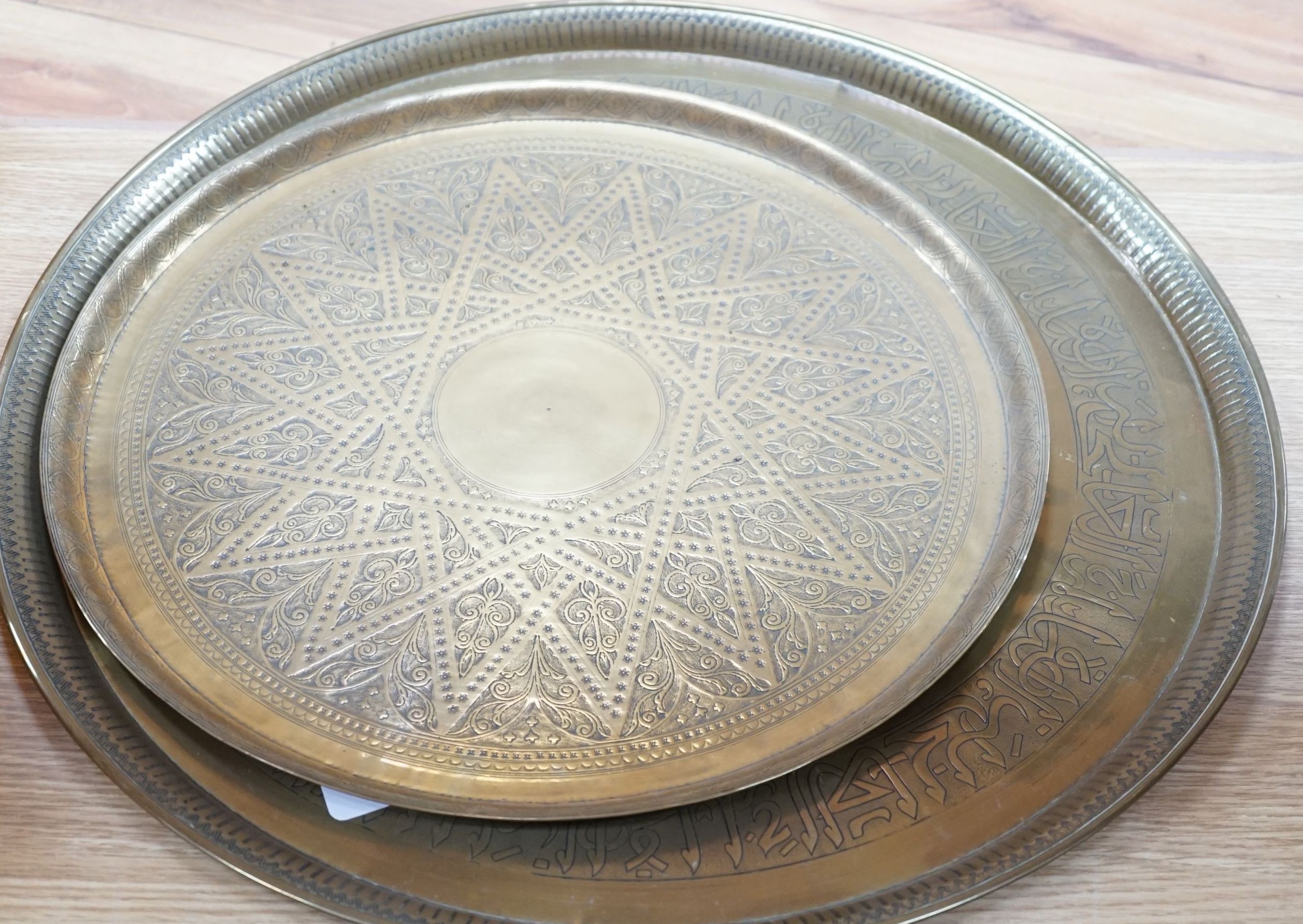 Two 19th century engraved brass circular trays, largest 58cm diameter